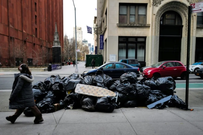 Une femme devant un tas de poubelles à Manhattan, New York le 19 mars 2024