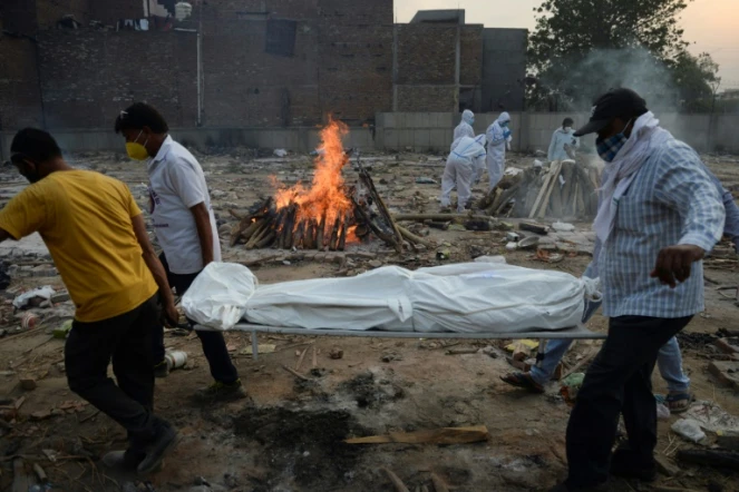 Des proches assistent à la crémation d'une personne décédée du Covid-19 au crematorium de New Delhi le 11 mai 2021
