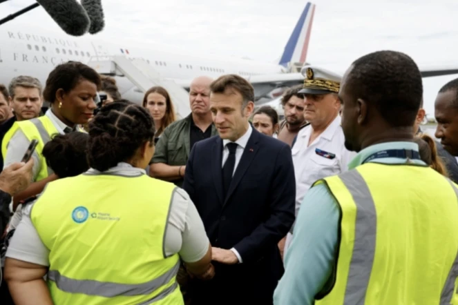 Emmanuel Macron s'entretient avec des membres du personnel de l'aéroport de Dzaoudzi, à Mayotte, le 19 décembre 2024 ( POOL / Ludovic MARIN )