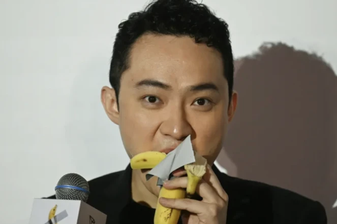 Justin Sun avalant la banane qu’il a achetée, une semaine plus tôt aux enchères, près de 6 millions d’euros.