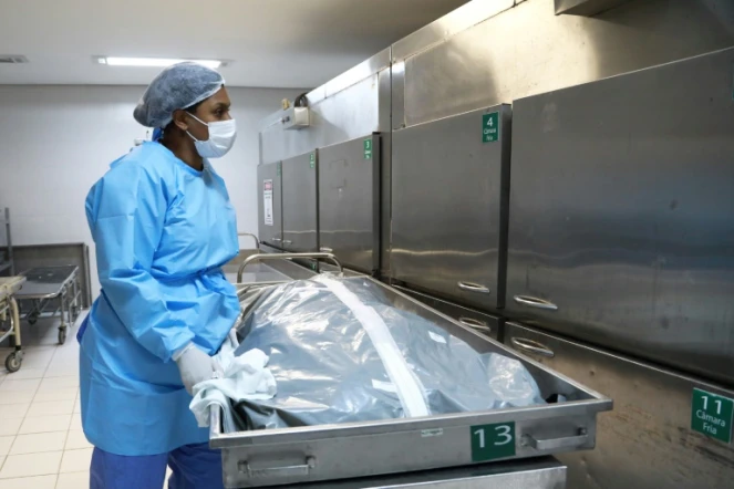 Une employée de morgue et le corps d'une victime du covid dans un hôpital de POrto Alegre (Brésil) le 4 mars 2021 