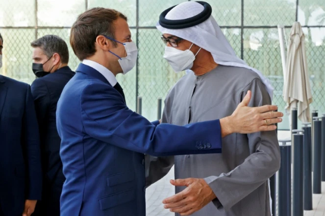 Le président français Emmanuel Macron (g) accueilli par le prince héritier d'Abou Dhabi Mohammed ben Zayed Al-Nahyane (d) à l'Exposition universelle de Dubaï, le 3 décembre 2021