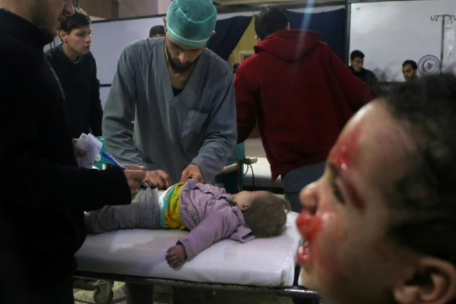 Des médecins syriens examinent une enfant dans un hôpital de fortune après des bombardements du régime syrien sur la ville de Douma dans la Ghouta orientale, le 22 février 2018
