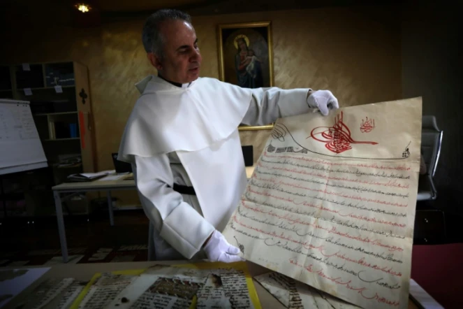 Le père Najeeb Michaeel
montre un manuscrit au Centre de numérisation des manuscrits orientaux (CNMO) à Erbil, dans le nord de l'Irak, le 1er mars 2018