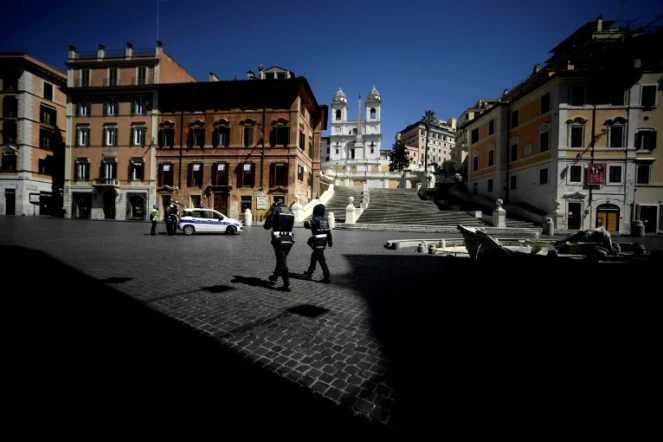 Des policiers en patrouille sur la Place d'Espagne déserte, le 1er avril 2020 à Rome