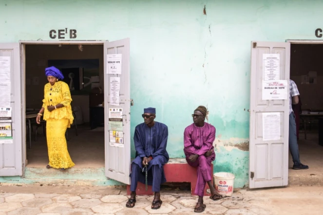 Deux hommes attendent devant un bureau de vote dans le quartier de Ngor, à Dakar, le 31 juillet 2022. Les élections législatives de dimanche au Sénégal constituent un test important pour le pouvoir.