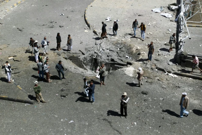 Des habitants autour d'un cratère provoqué par une frappe aérienne de la coalition arabe, le 1er octobre 2015 à Sanaa, au Yémen