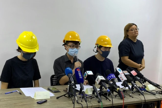 Trois membres du mouvement pro-démocratie, le visage couvert par un masque, donnent une conférence de presse "par le peuple, pour le peuple", le 6 août 2019 à Hong Kong 