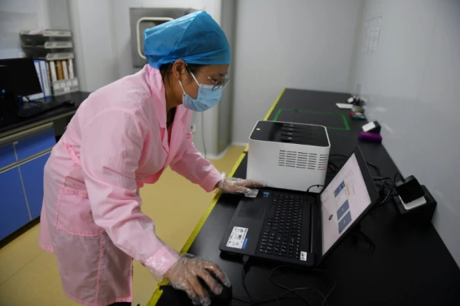 Une technicienne vérifie les résultats d'un test en utilisant le Flash 20, une machine conçue par l'entreprise chinoise de biotechnologie Coyote pour réaliser des
dépistages rapides au nouveau coronavirus, le 27 septembre 2020 à Pékin