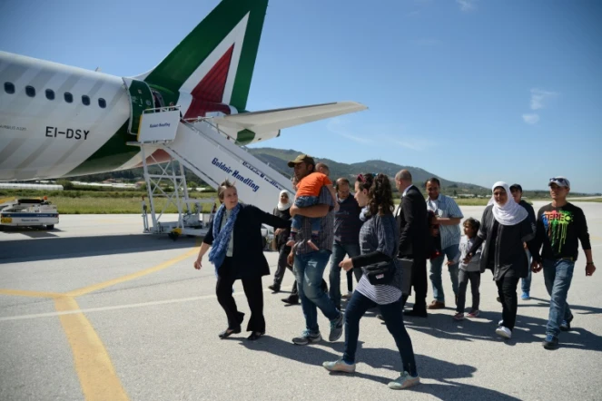 Des familles de réfugiés syriens embarquent à bord de l'avion du pape le 16 avril 2016 à l'aéroport de Mytilène 