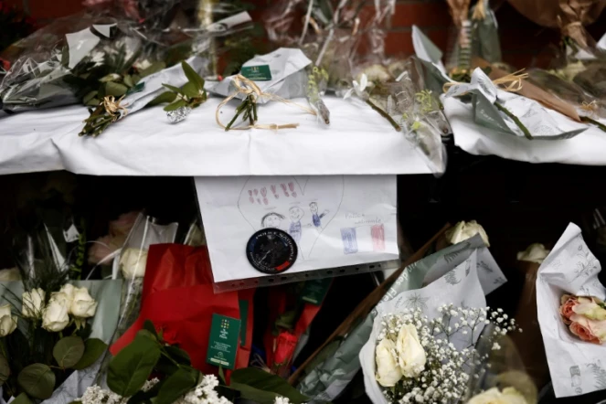 Des fleurs déposées devant le commissariat de Roubaix en hommage aux trois policiers morts la veille dans un accident de la route, le 22 mai 2023 dans le Nord