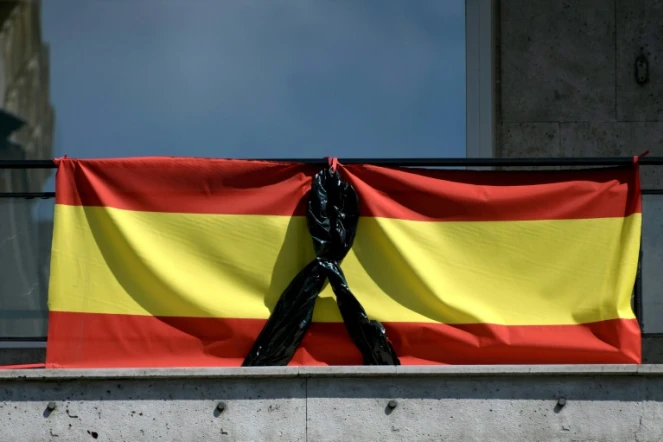 Le drapeau espagnol orné d'un ruban noir, pour les malades et les morts dûs au Covid-19, sur un balcon à Madrid le 8 avril 2020