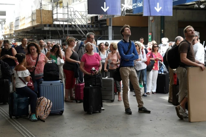 Les voyageurs patientent dans les halls de la gare Montparnasse à Paris, le 28 juillet 2018