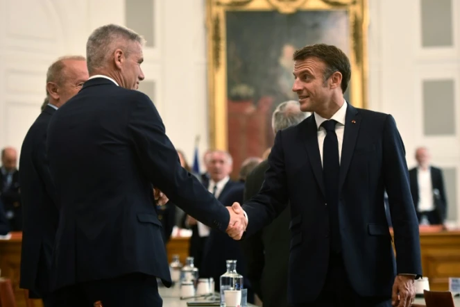 Le président français Emmanuel Macron (d) salue des élus locaux durant une visite à Pau, le 6 juillet 2023