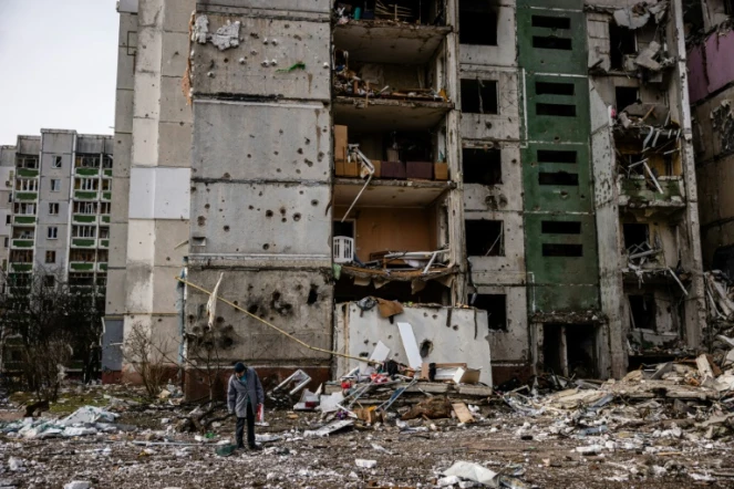 Un homme se tient devant un immeuble résidentiel touché par les bombardements sur la ville de Tcherniguiv en Ukraine le 4 mars 2022
