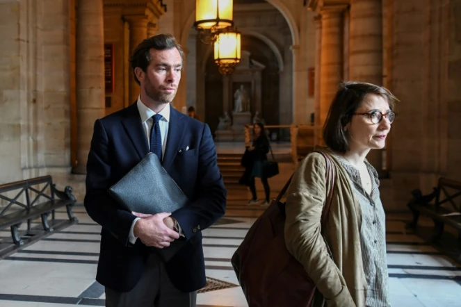 Pierre-Louis Baudey-Vignaud (G) arrive avec l'avocate Marie Dosé (D) au procès du Britannique Ian Bailé accusé du meurtre de sa mère, devant la cour d'assises de Paris, le 27 mai 2019.
