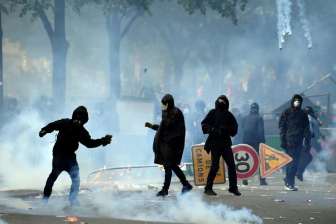 Un manifestant envoie un pavé contre des CRS, en marge du défilé syndical du 1er mai 2018, à Paris