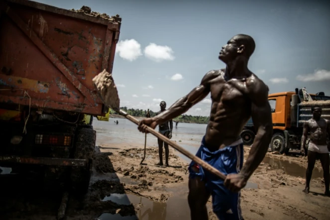 Des ouvriers congolais emplissent de sable des bennes, sur la berge de la rivière Congo, près de Brazzaville le 28 mars 2016