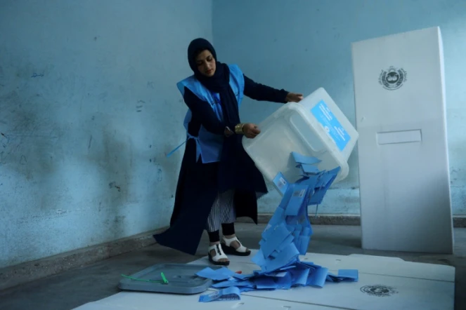 Une responsable de la commission électorale en Afghanistan vide une urne pour le comptage des voix après la fermeture des bureaux de vote pour l'élection présidentielle, le 28 septembre 2019