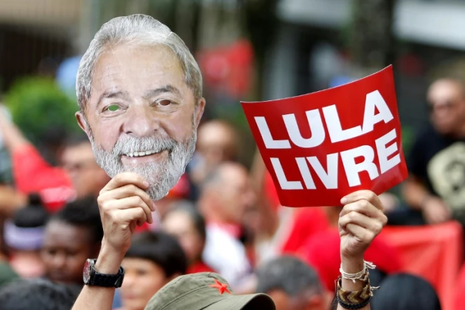 Un partisan de Lula brandit un masque représentant le visage de l'ancien président brésilien et une pancarte "Lula libre" au lendemain de sa libération, lors d'un rassemblement devant le siège des métallos de Sao Bernardo do Campo, près de Sao Paulo, le 9 novembre 2019