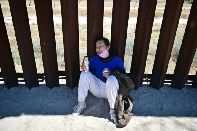 Une migrante chinoise, épuisée par la chaleur, se repose sur le mur frontalier après être entrée à pied aux États-Unis à Jacumba Hot Springs (Californie), le 5 juin 2024