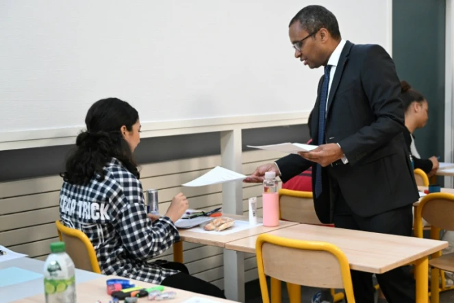 Le ministre de l'Éducation Pap Ndiaye distribue des copies d'examen aux élèves, alors qu'ils commencent l'épreuve de philosophie, à Paris, le 14 juin 2023