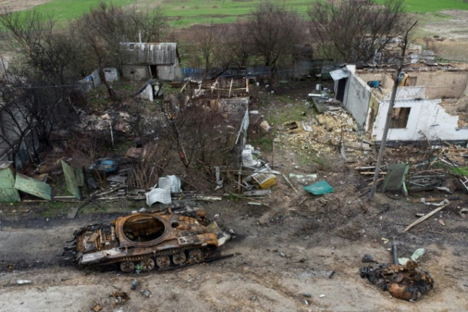 Epave d'un tank près de maisons détruites dans le village de Zalissya (Ukraine), au nord-est de Kiev, le 19 avril 2022