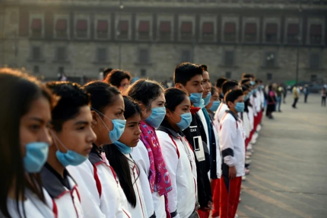 Des étudiants portant des masques pour se protéger des effets néfastes de la pollution lors d'une cérémonie Place Zocalo à Mexico le 17 mai 2019