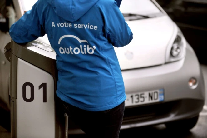 Un employé d'Autolib' devant une voiture en autopartage, le 9 mai 2012 à Paris