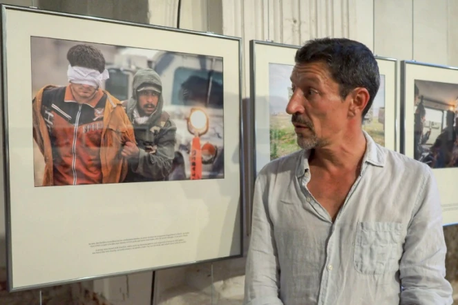 Le photographe français Frédéric Lafargue pose devant sa série de photos intitulée "Echapper à Daech", le 1er septembre 2016 à Perpignan