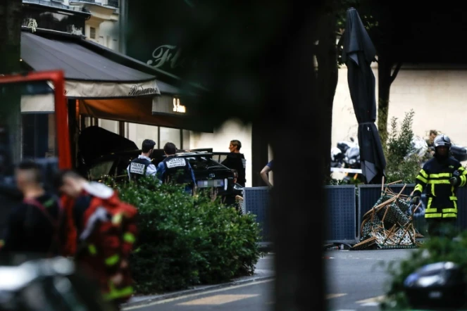 Des policiers près du lieu où un automobiliste a foncé sur la terrasse d'un café, le 17 juillet 2024 à Paris