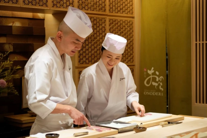  Mizuho Iwai (d) apprend auprès d'un maitre sushi dans le restaurant Onodera à Tokyo, le 27 novembre 2019 la façon de préparer le poisson