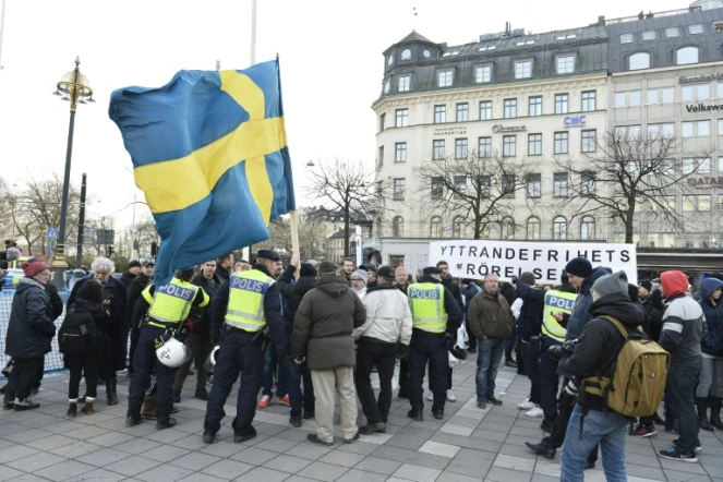 Des policiers suédois s'adressent à des manifestants, le 30 janvier 2016 à Stockholm qui s'opposent à l'arrivée de migrants dans leur pays