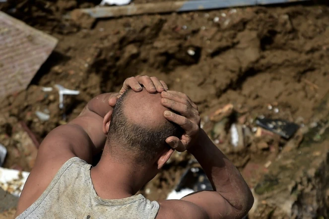 Un homme réagit devant les dégâts laissés par un glissement de terrain à Petropolis (sud-est du Brésil), le 16 février 2022