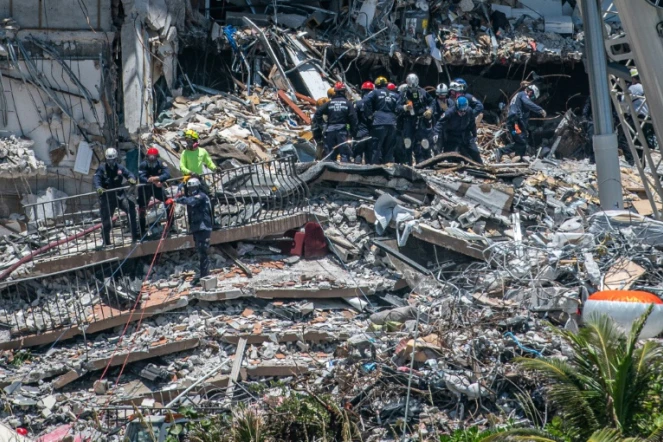 Des secouristes fouillent les décombres d'un immeuble effrondré à Surfside en Floride, le 27 juin 2021