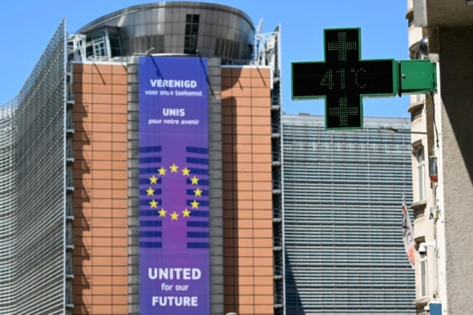 Un thermomètre de pharmacie affiche 41°C, avec en arrière-plan le siège de la Commission européenne, à Bruxelles, le 23 juin 2025