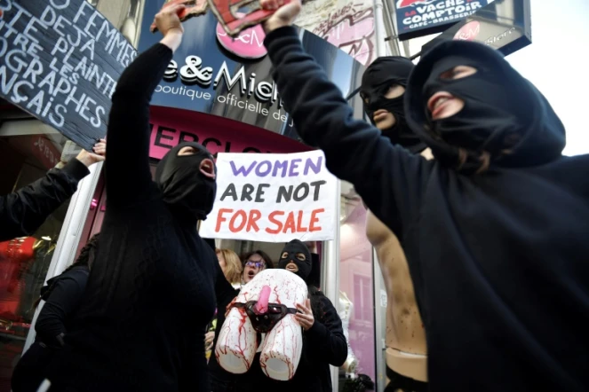 Des membres du collectif féministe "Les Amazones" participent à une action devant le sex-shop "Jacquie et Michel" pour dénoncer les condition des femmes dans l'industrie pornographique, à Paris, le 19 février 2022