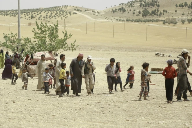 Des familles syriennes qui fuient l'assaut lancé par les forces arabes et kurdes contre le groupe Etat islamique à Minbej, arrivent dans un campement à 20 kms de la ville le 4 juin 2016 