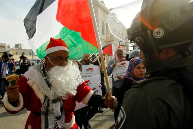 Un manifestant palestinien habillé en père Noël s'oppose à un membre des forces de l'ordre israélienne à Bethléem, en Cisjordanie occupée, le 23 décembre 2017