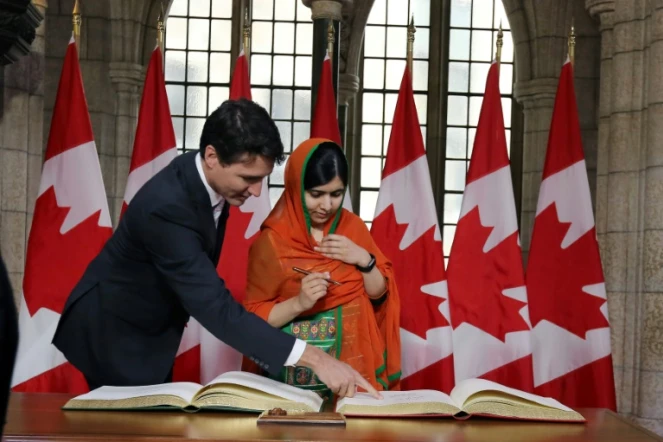 Malala Yousafzai signe un livre d'or avec Justin Trudeau, au Parlement à Ottawa le 12 avril 2017