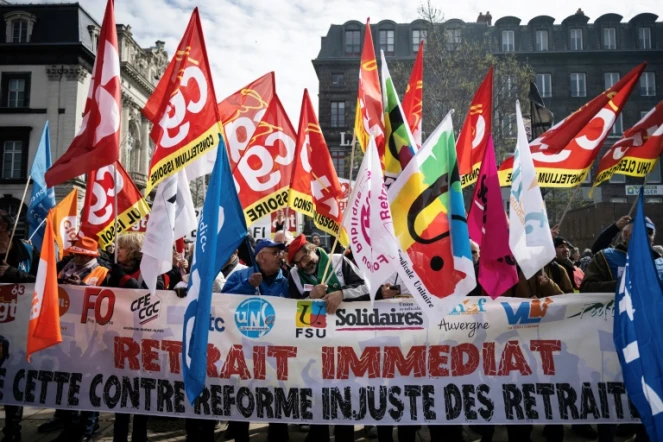 Mobilisation contre la réforme des retraites de manifestants brandissant des drapeaux de syndicats, le 28 mars 2023 à Clermont-Ferrand