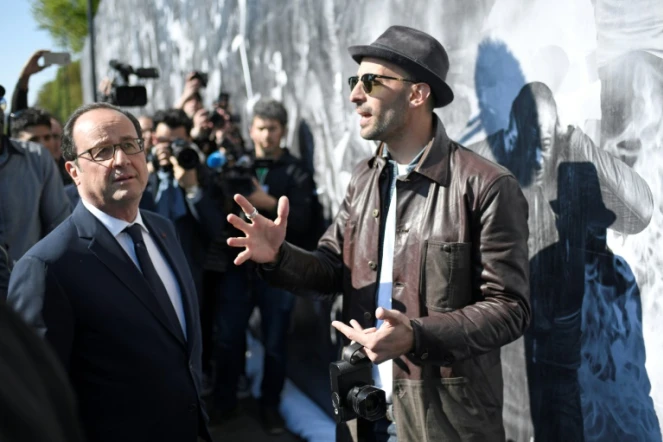 Le président François Hollande (g) et l'artiste JR (d), le 19 avril 2017 à Clichy-sous-Bois en banlieue parisienne