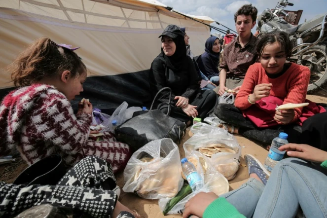 Des manifestants palestiniens mangent près d'une tente le 30 mars 2018 lors d'une manifestation près de la frontière avec Israël, dans le sud de la bande de Gaza