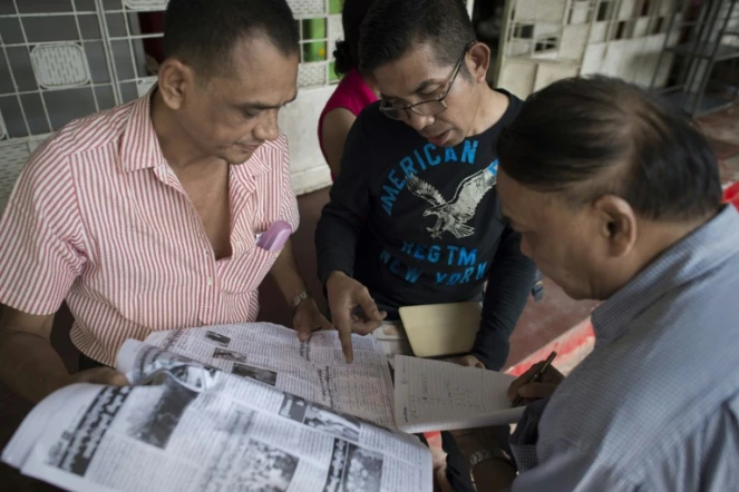 Les partisans d'Aung San Suu Kyi consultent les résultats des élections dans un quotidien le 10 novembre 2015 à Rangoun