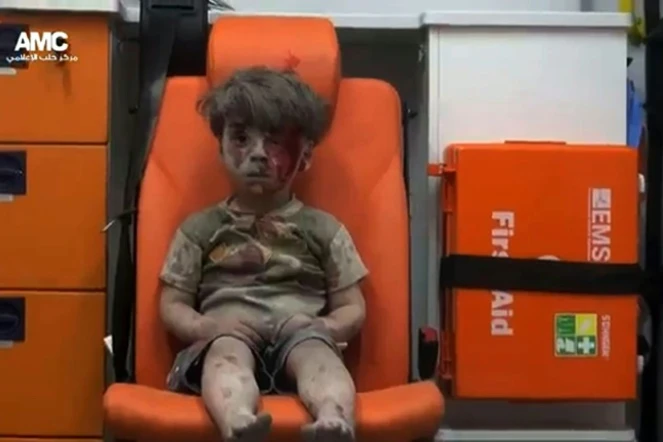 Le petit Omrane, 4 ans, assis à l'arrière d'une ambulance après avoir été sauvé d'un immeuble bombardé à Alep le 17 août 2016