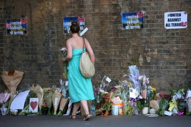 Une femme dépose des fleurs près des lieux d'une attaque contre des piétons devant une mosquée à Londres, le 19 juin 2017