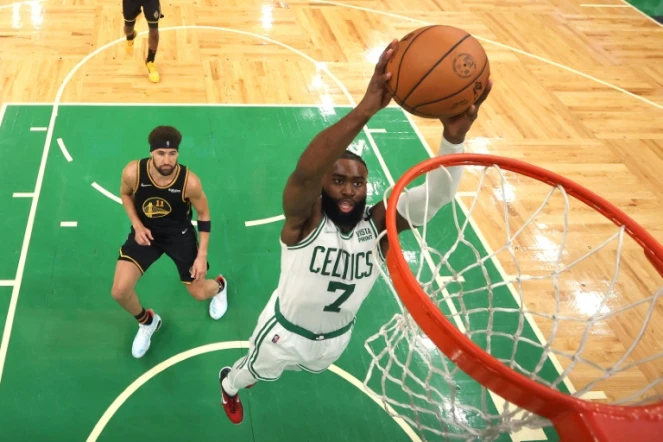 Jaylen Brown (c.), des Boston Celtics, tente un dunk contre Klay Thompson (g.), des Golden State Warriors, lors du troisième match des finales NBA, à Boston, le 8 juin 2022