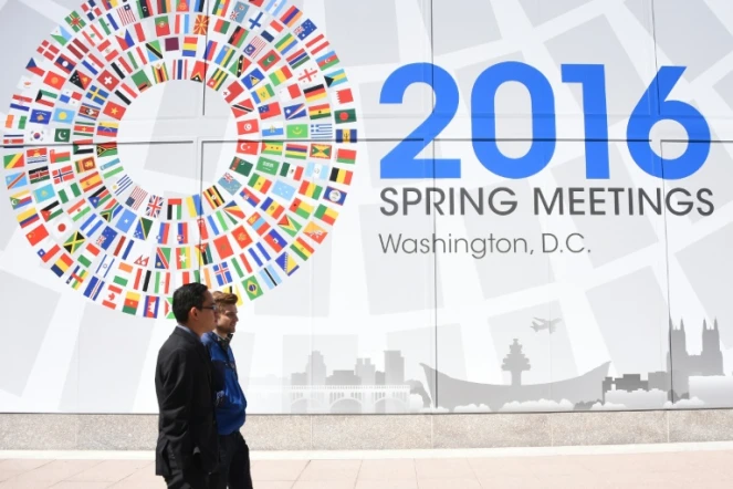 Deux hommes passent devant un panneau annonçant le meeting du monde de la finance à Washington, le 13 avril 2016