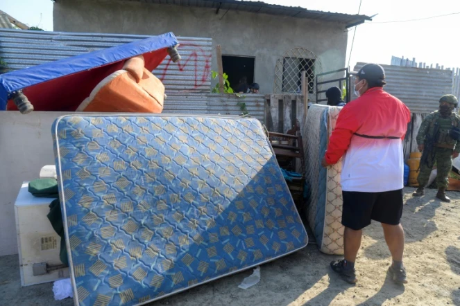Un homme sort les meubles et les biens des personnes qui avaient extorqué et expulsé sa famille après avoir récupéré sa maison lors d'une opération de l'armée et de la police à Duran, le 23 juillet 2024 en Equateur