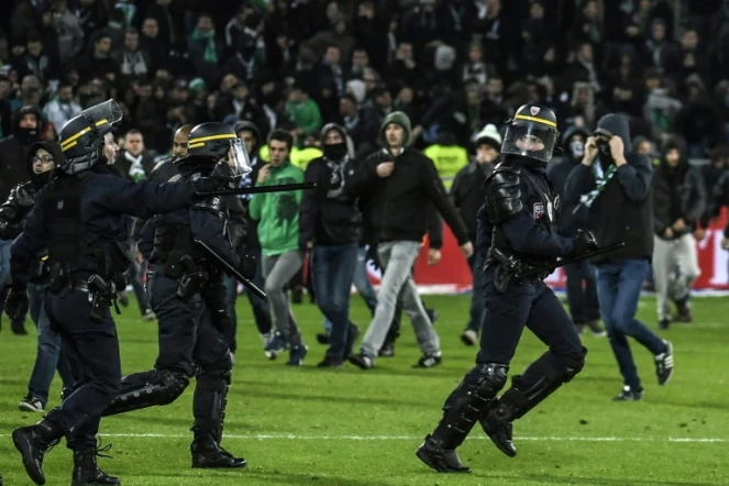 Les forces de sécurité tentent de disperser des supporters ayant envahi la pelouse de Geoffroy-Guichard lors du derby Saint-Etienne-Lyon, le 5 novembre 2017